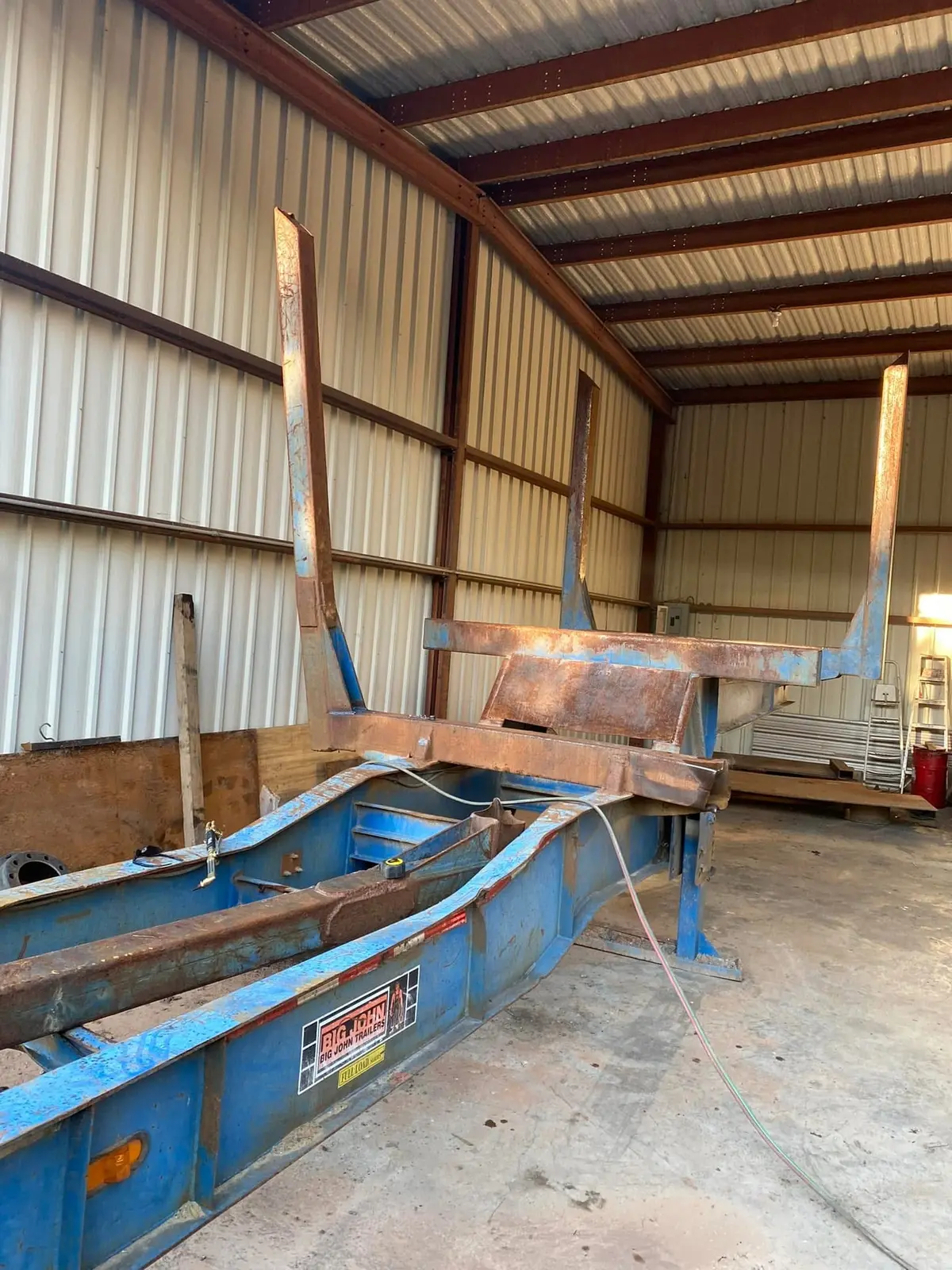 Heavy logging trailer undergoing structural fabrication and repair